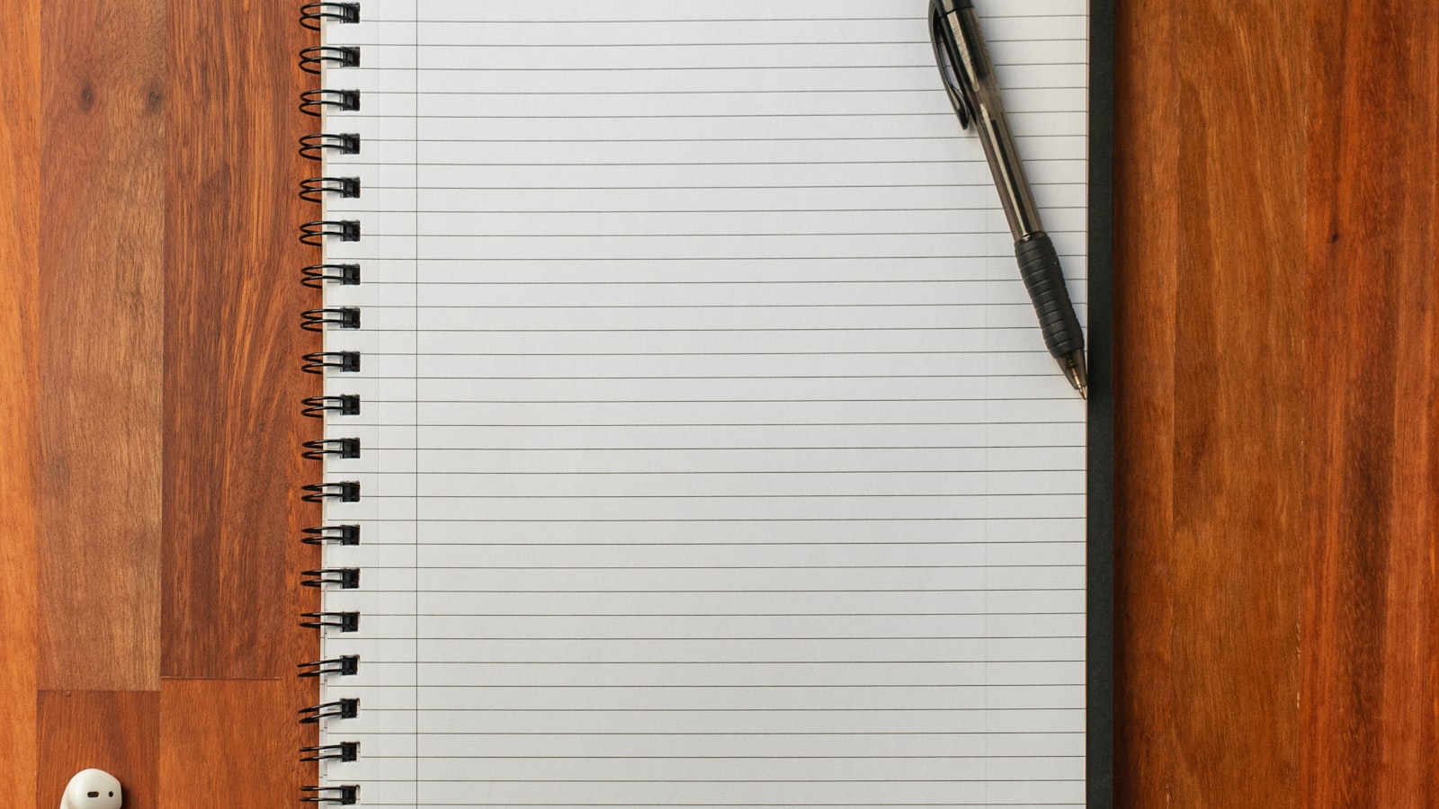 Stylo posé sur un carnet blanc pour rédiger un brief